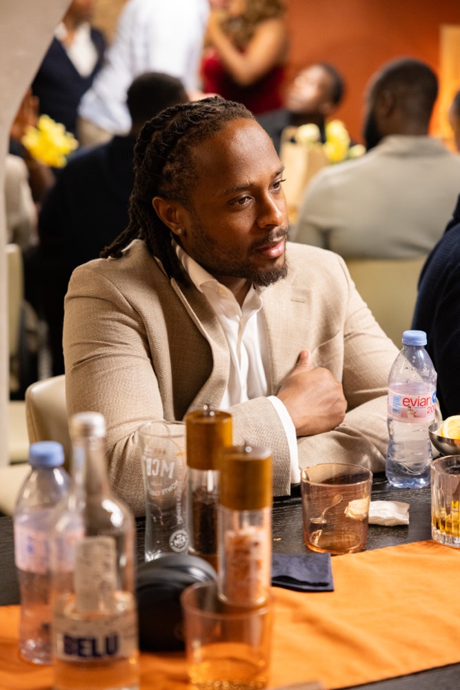A guest in a cream suit at the table